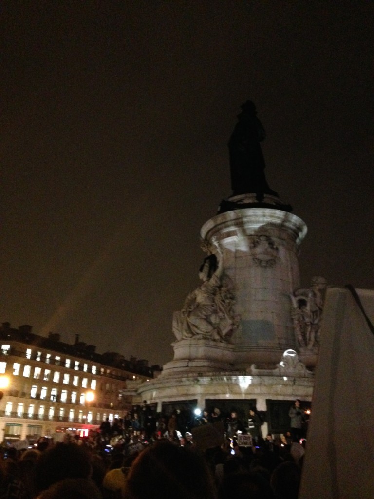 Un homme monte pour passer un brassard noir à la statue de la Liberté.